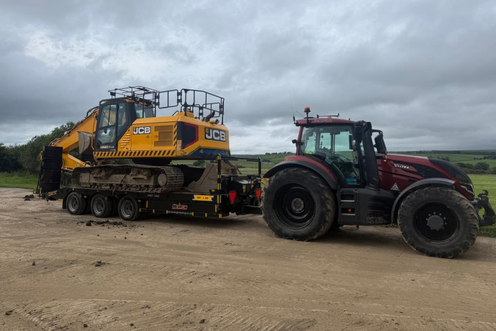 Tractor towing an excavator